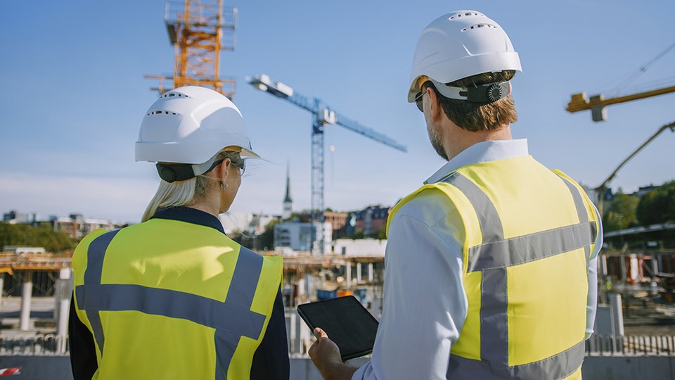 Construction site team recording progress on a tablet